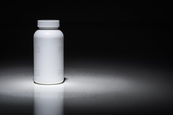 Blank white bottle ready for your text under spot light