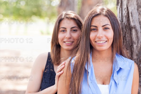 Two beautiful ethnic twin sisters portrait outdoors