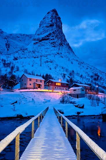 Bridge in Reine village covered with snow at night. Lofoten islands