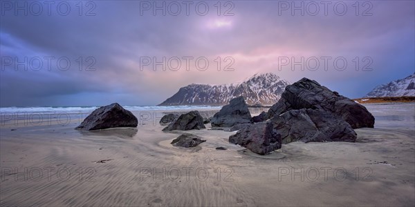 Beach of Norwegian sea on rocky coast in fjord on sunset. Skagsanden beach