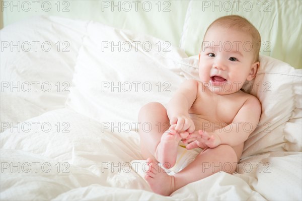 Young mixed-race chinese and caucasian baby boy having fun on his blanket