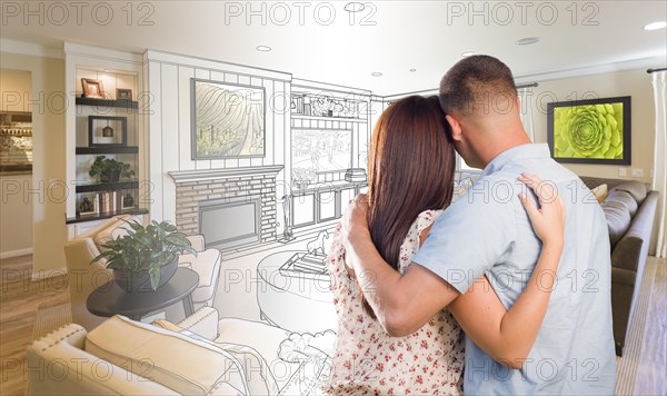 Curious young military couple looking over custom living room design drawing photo combination