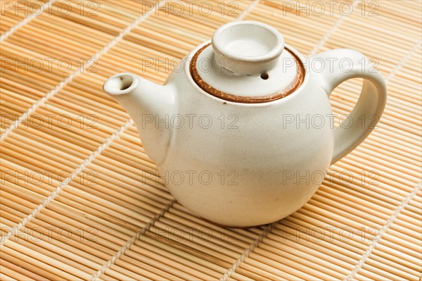 Chinese teapot on bamboo mat close up photo