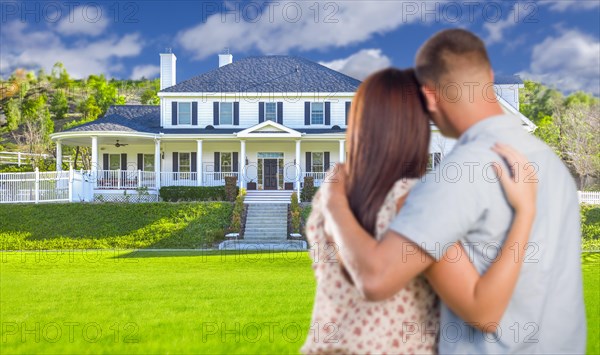 Affectionate military couple looking at nice new house