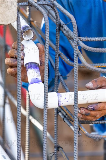 Plumber installing PVC pipe at construction site