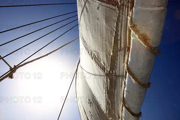 White sail of a sailboat against blue sky