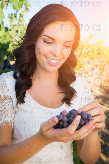 Beautiful young adult woman enjoying A walk in the grape vineyard