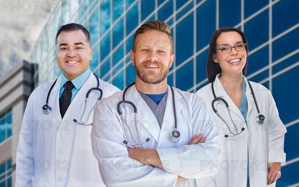 Group of mixed-race male and female doctors or nurses in front of hospital building