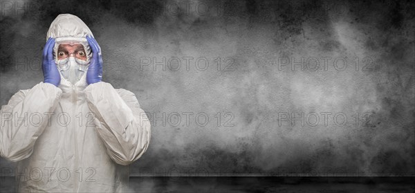 Man wearing hazmat suit and goggles in smokey room banner with copy space