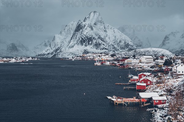 Reine fishing village on Lofoten islands with red rorbu houses in winter with snow. Norway