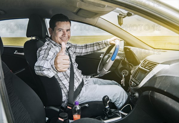 Man in his car giving a thumbs up