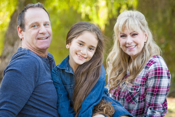 Caucasian grandmother and grandfather with young mixed-race grandaughter outdoors