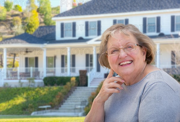 Senior adult woman in front of beautiful house