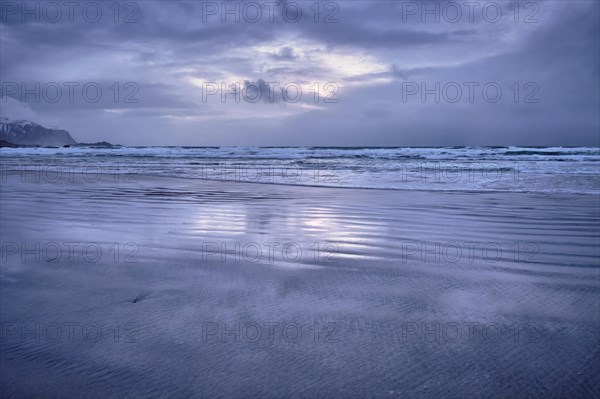 Beach of Norwegian sea on rocky coast in fjord on sunset. Skagsanden beach