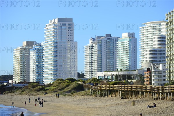 Wooden jetty on the beach in front of high-rise buildings with flats