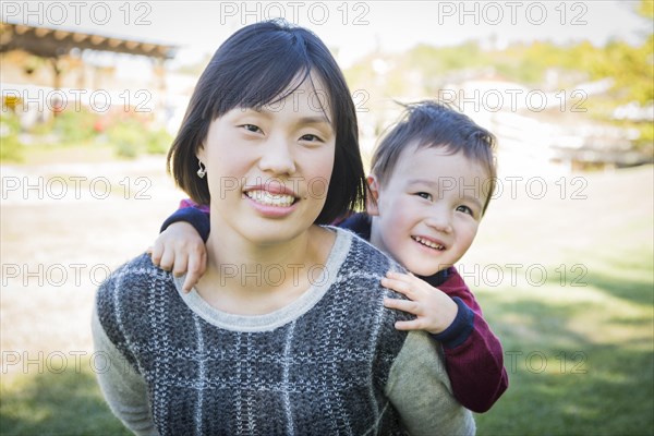 Happy chinese mother having fun with her mixed-race baby son