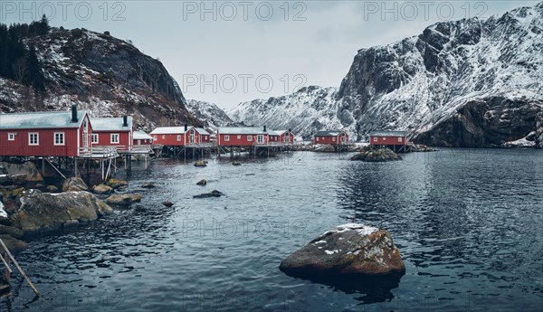 Nusfjord authentic traditional fishing village with traditional red rorbu houses in winter in Norwegian fjord. Lofoten islands