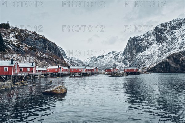 Nusfjord authentic traditional fishing village with traditional red rorbu houses in winter in Norwegian fjord. Lofoten islands