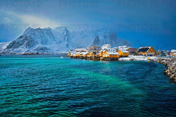 Yellow rorbu houses of Sakrisoy fishing village with snow in winter. Lofoten islands