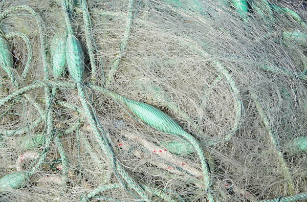 White fishing net with green dew and floats
