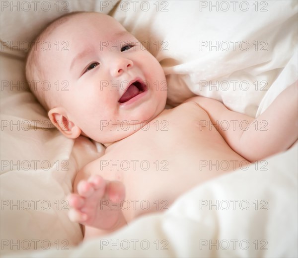 Young mixed-race chinese and caucasian baby boy having fun on his blanket