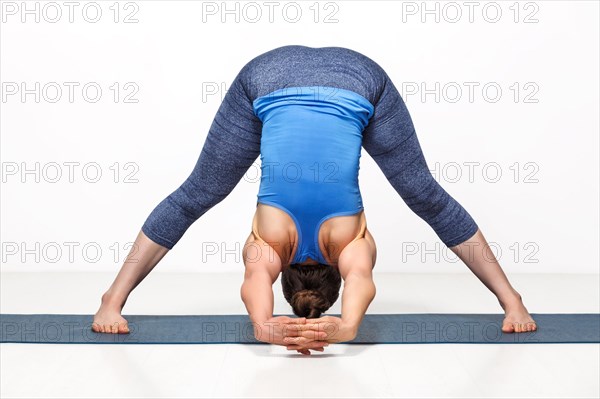 Beautiful sporty fit woman practices Ashtanga Vinyasa yoga asana Prasarita padottanasana C