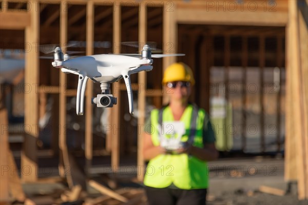 Female pilot flies drone quadcopter inspecting construction site