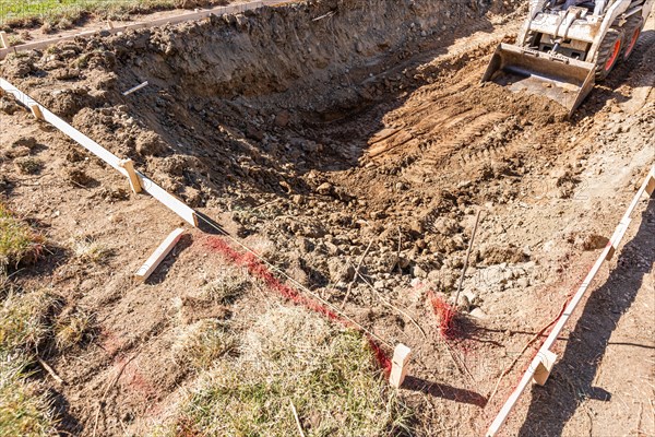 Small bulldozer digging in yard for pool installation