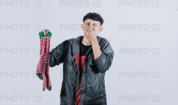 Person holding a stinky sock in his hand