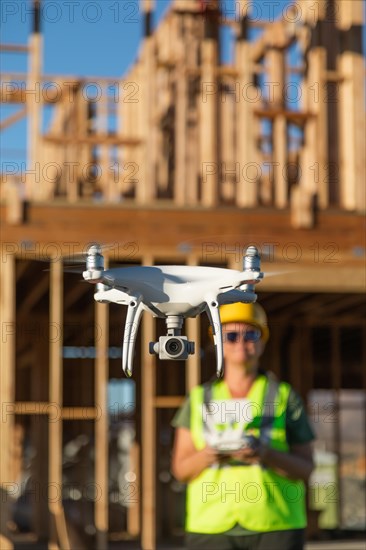 Female pilot flies drone quadcopter inspecting construction site