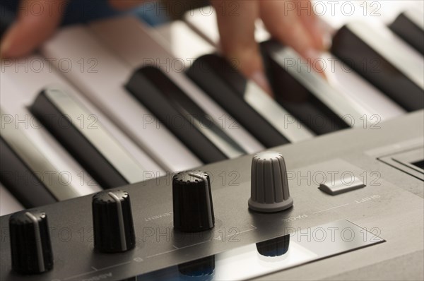 Woman's fingers on digital piano keys