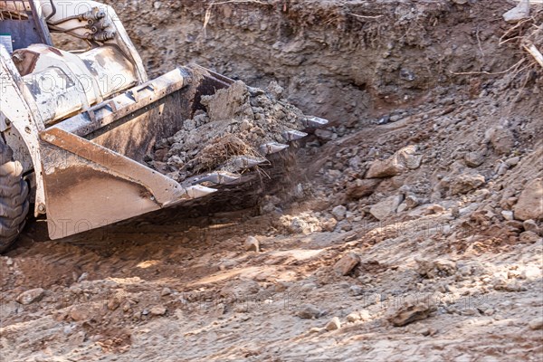 Small bulldozer digging in yard for pool installation