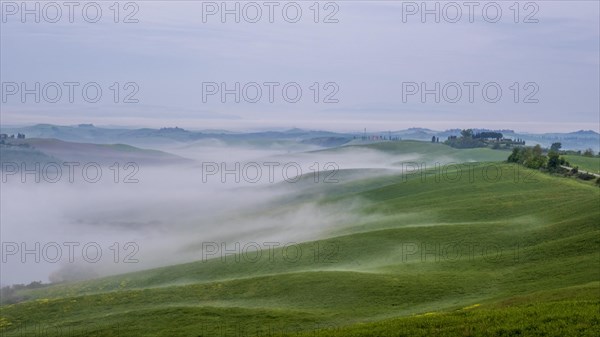Sunrise with foggy atmosphere in the hilly landscape