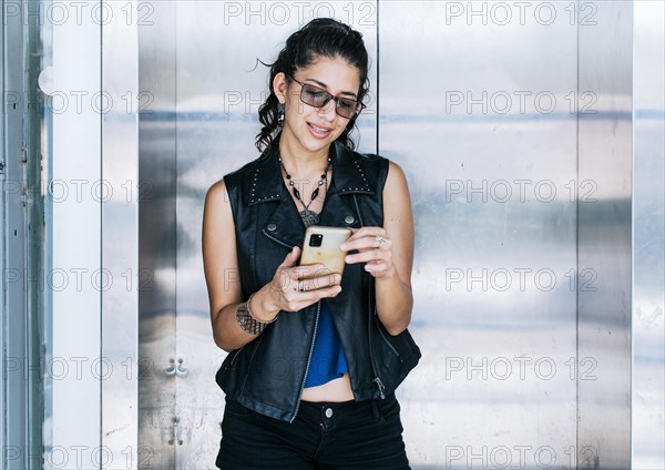 Attractive girl using her cell phone at the elevator door