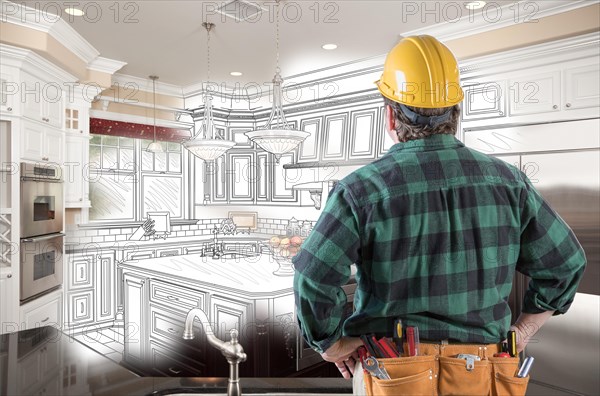 Male contractor with hard hat and tool belt looking at custom kitchen drawing photo combination on white