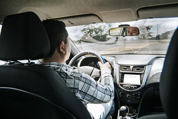 Back view of a man driving a car