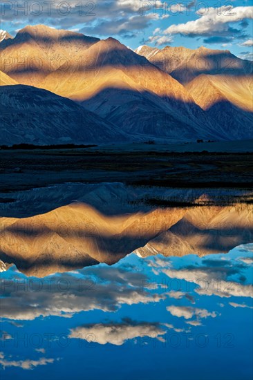 Himalayas on sunset with camel caravan. Hunber