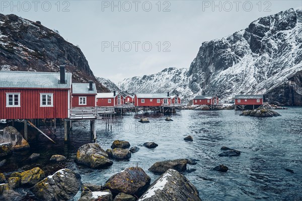 Nusfjord authentic traditional fishing village with traditional red rorbu houses in winter in Norwegian fjord. Lofoten islands