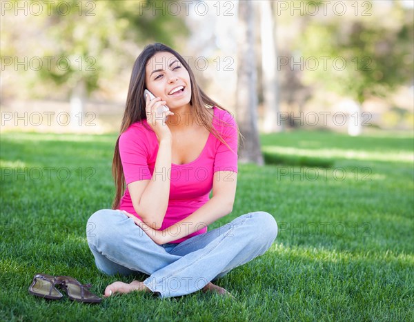 Beautiful young ethnic woman talking on her smartphone outside