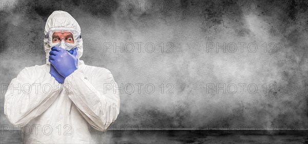 Man wearing hazmat suit and goggles in smokey room banner with copy space