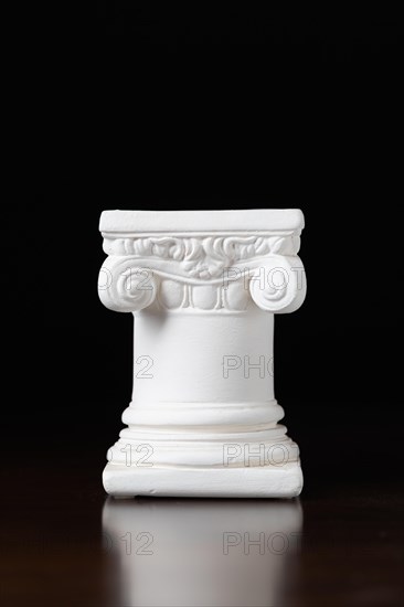 White ionic design column on dark background