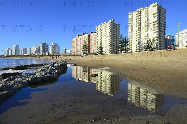 High-rise buildings with flats reflected in the water on the beach