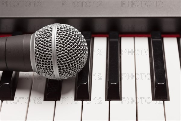 Microphone laying on electronic synthesizer keyboard abstract