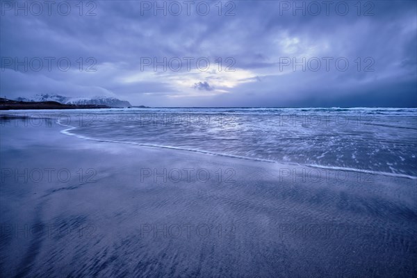 Beach of Norwegian sea on rocky coast in fjord on sunset. Skagsanden beach