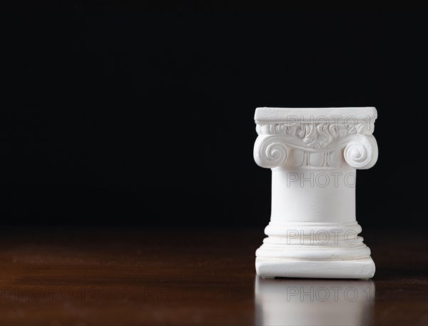 White ionic design column on dark background