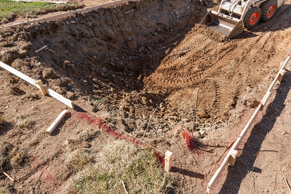 Small bulldozer digging in yard for pool installation