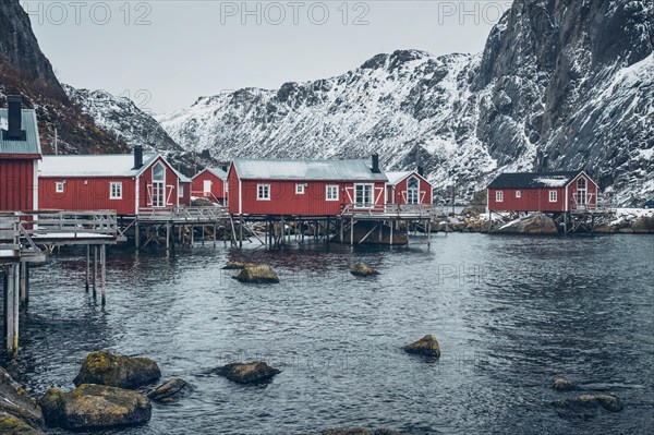 Nusfjord authentic traditional fishing village with traditional red rorbu houses in winter in Norwegian fjord. Lofoten islands