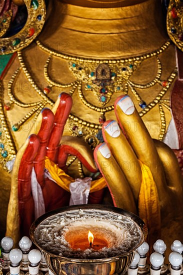 Maitreya Buddha hands with burning lampion in Thiksey Gompa. Ladakh