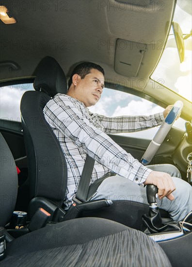 Interior view of a young man driving a car