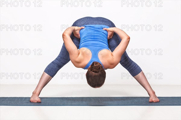 Beautiful sporty fit woman practices Ashtanga Vinyasa yoga asana Prasarita padottanasana B